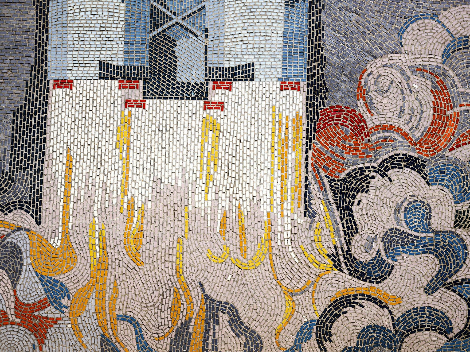 Foto: in einem Mosaik verbinden sich kleine Steinchen zu bewegten Formen, unten eher wolkenartig, oben geometrisch-gerade. Gelb, Rot und Blau überwiegen im Zusammenspiel mit Weiß, Grau und Schwarz.