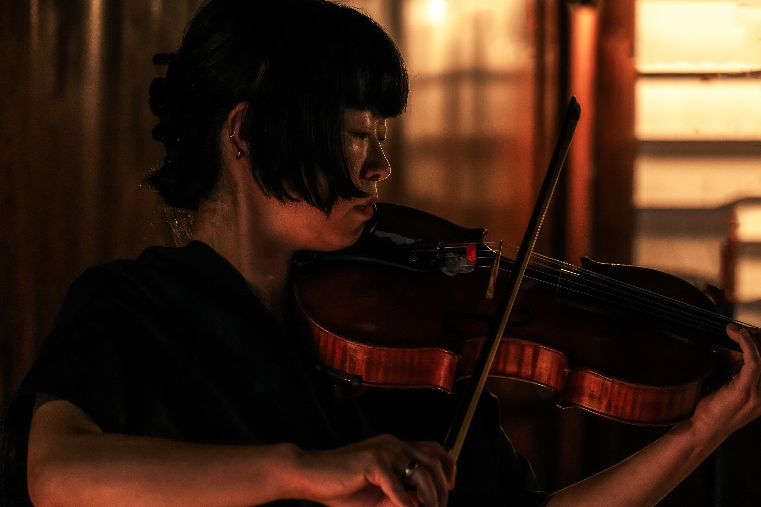 Foto: Portrait der Musikerin Atsuko Hatano, auf der Geige spielend. 