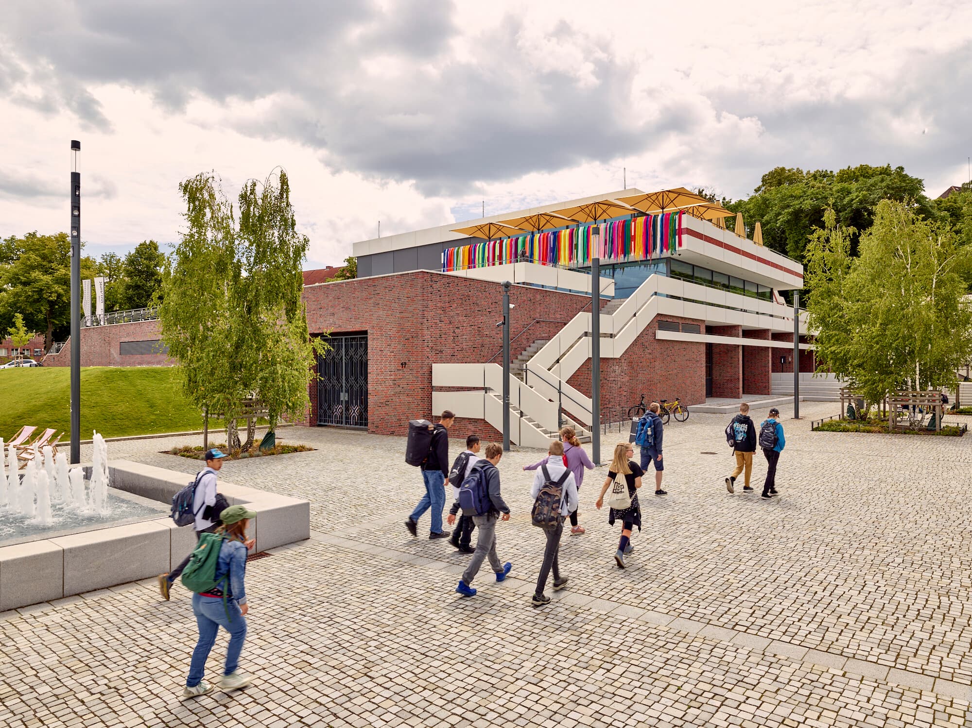 Foto: Kinder mit Schulmappen auf dem Rücken laufen am MINSK Kunsthaus in Potsdam entlang. 