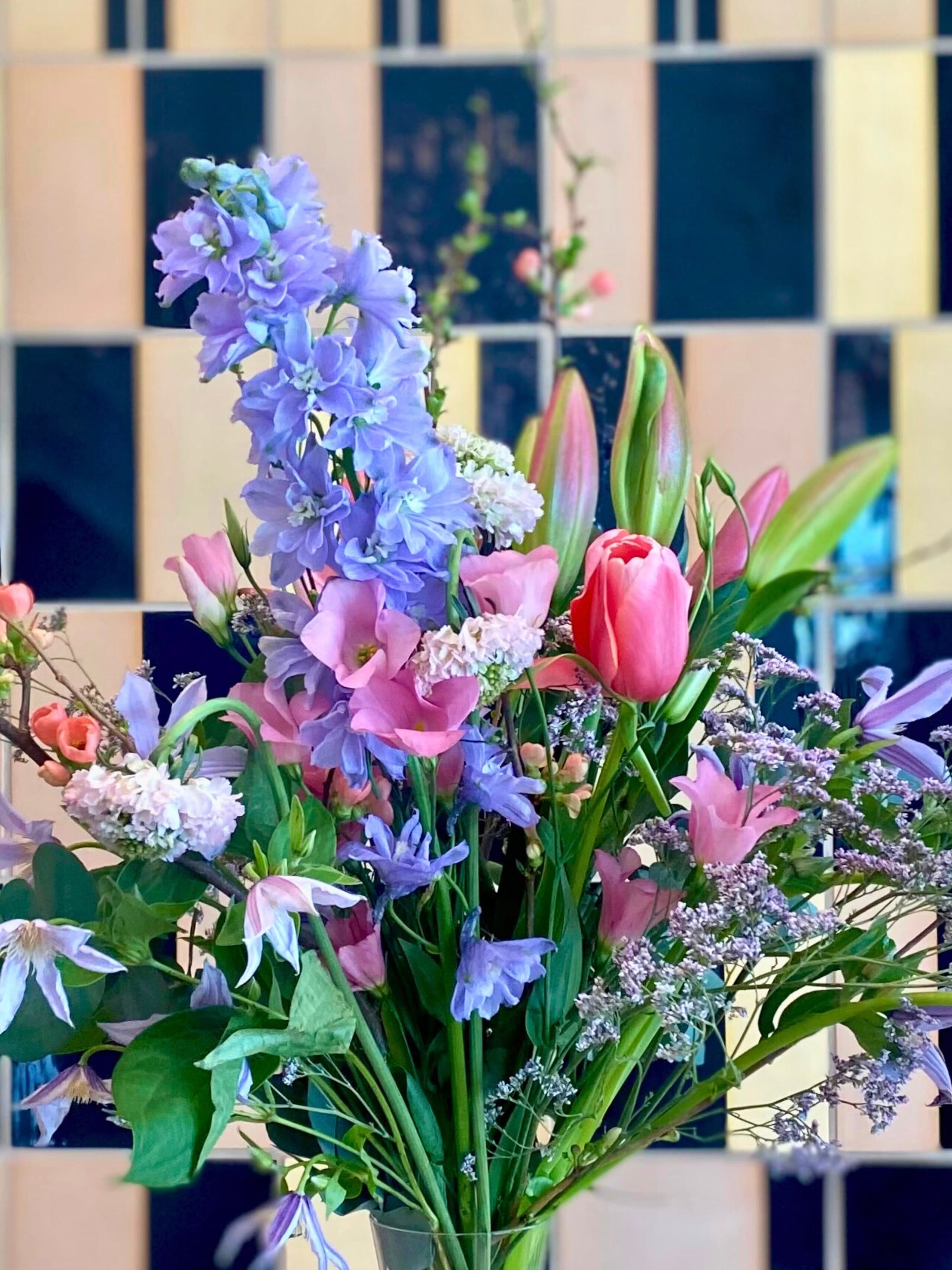 Foto eines bunten Blumenstraußes vor den Hedwig Bollhagen Fliesen im MINSK.