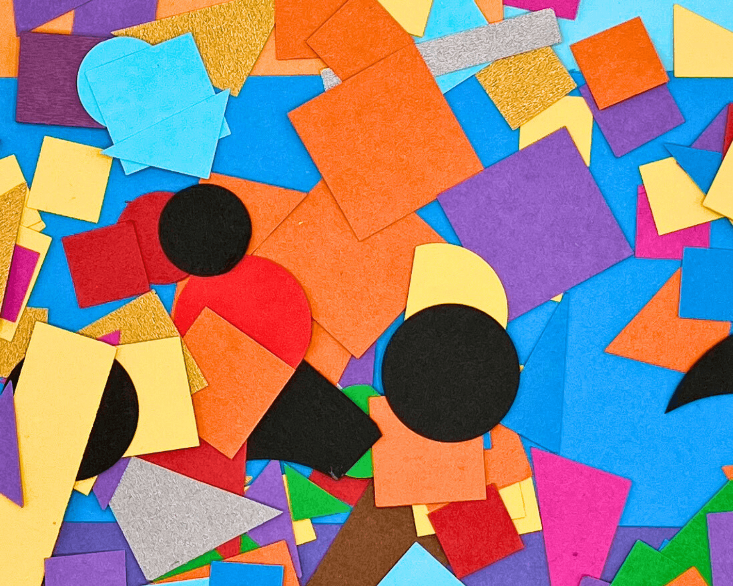 Foto: viele bunte Papierschnipsel liegen ausgebreitet auf einem Tisch, bereit zum Basteln und Gestalten. 