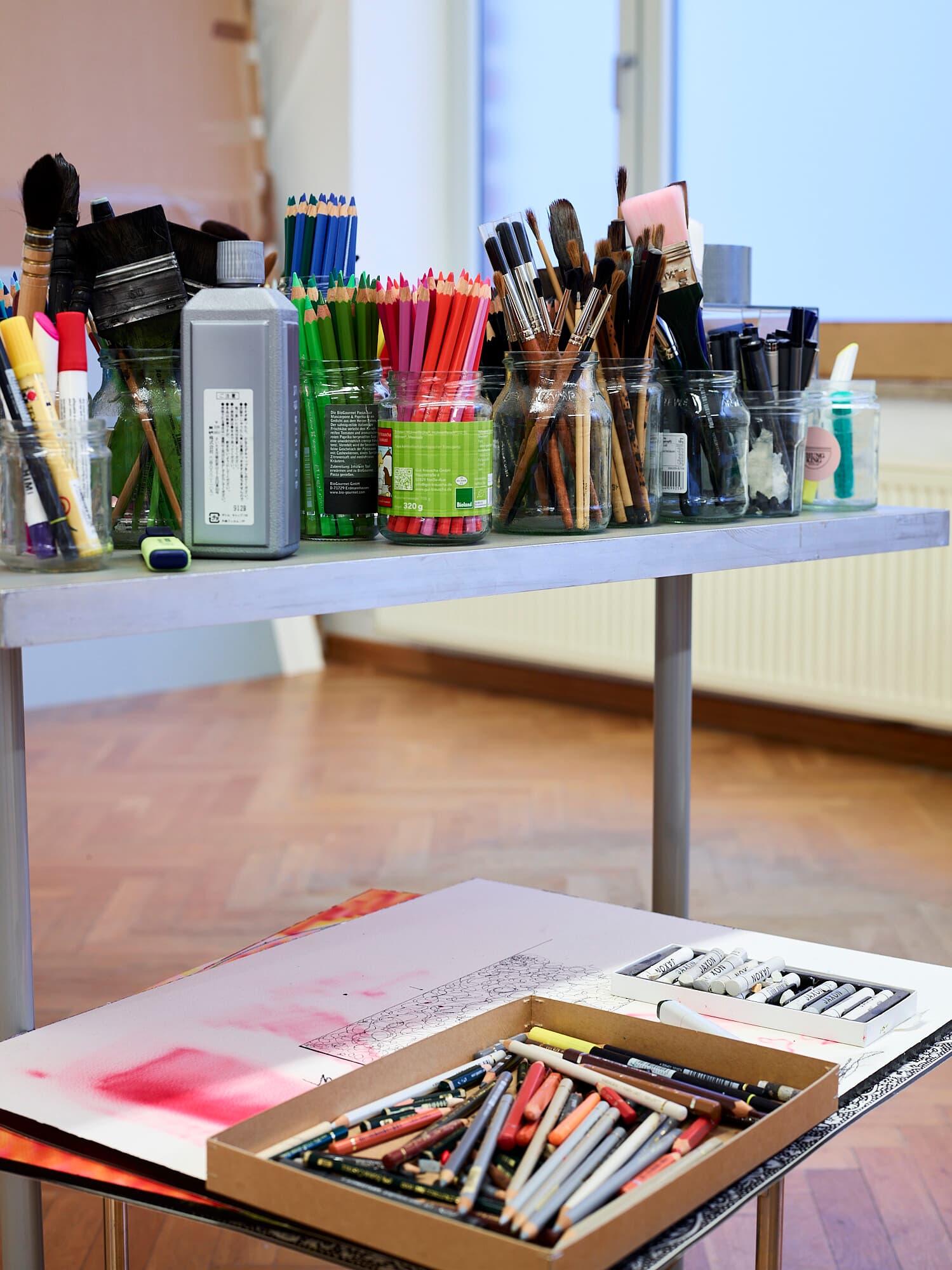 Photo: an indoor space. Everything is prepared for an art workshop. Glasses with brushes, paints and other painting utensils are ready.